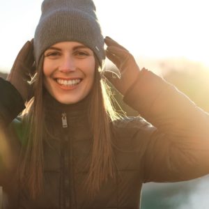 A woman wearing an insulated jacket and a hat